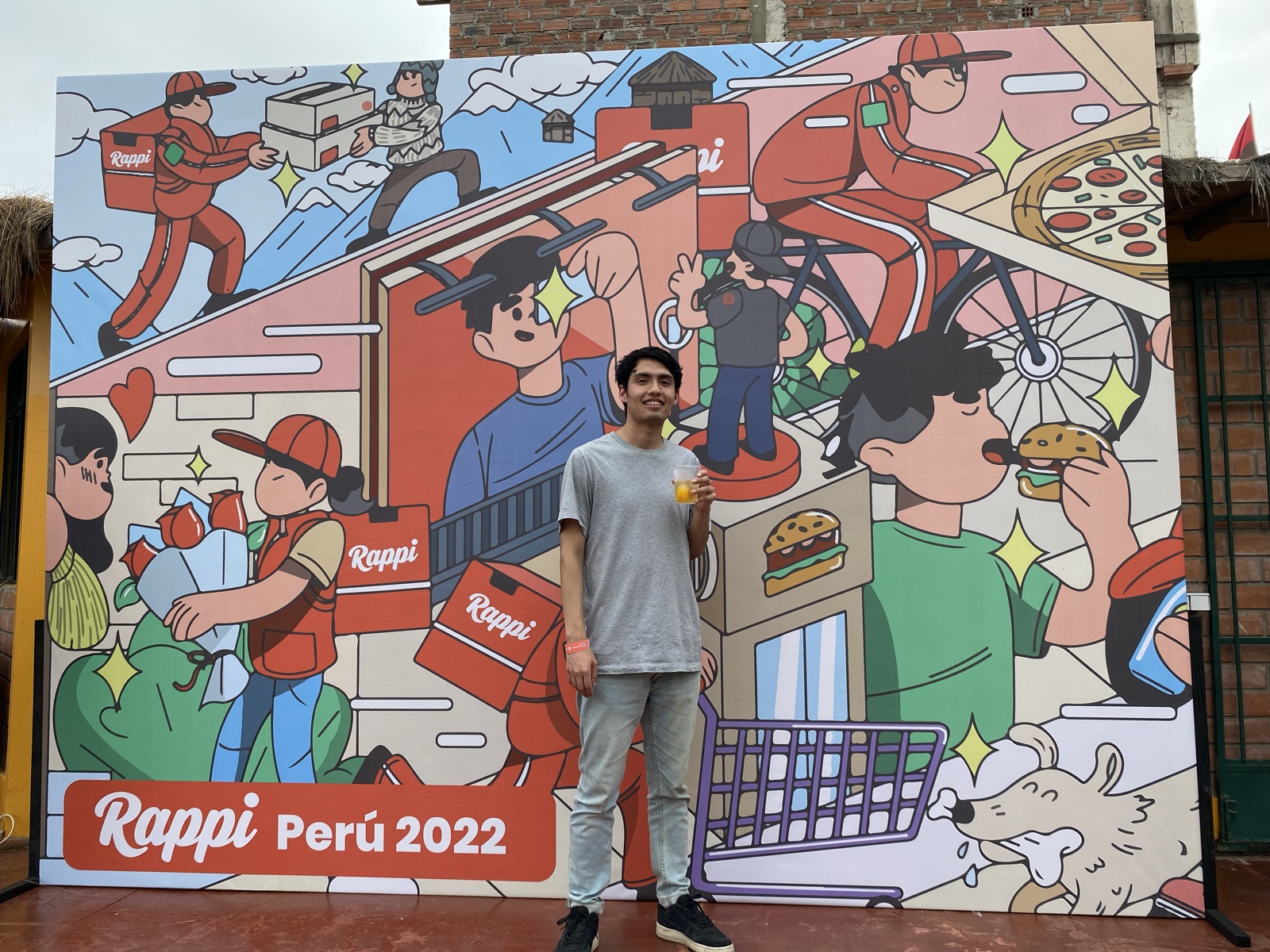 Posing in front of the illustrated Rappi Perú 2022 event backdrop