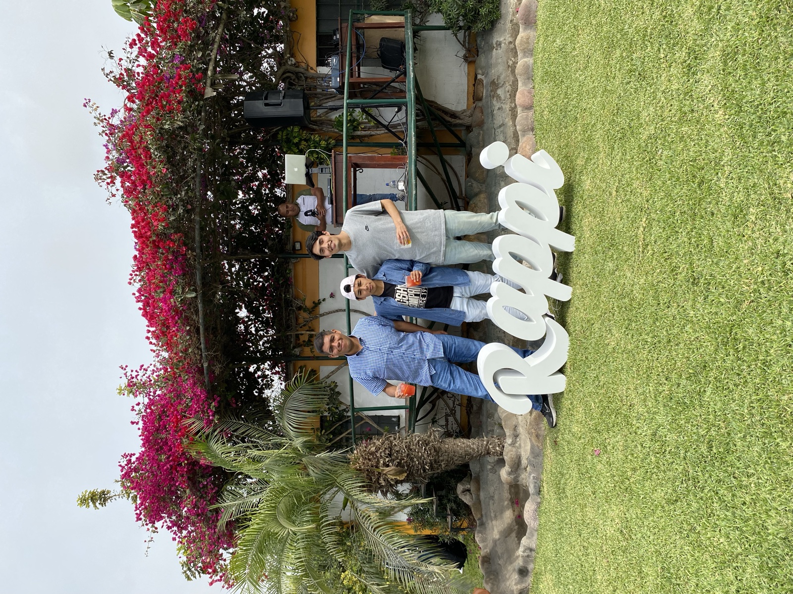 Three colleagues together behind a Rappi sign at an outdoor event